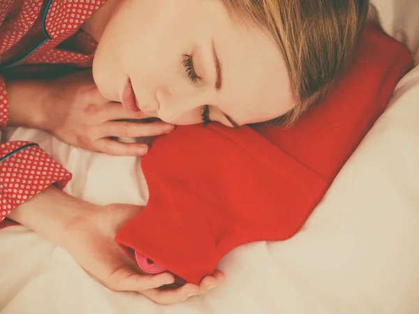 Vrouw slapen met warme rode warm waterfles — Stockfoto