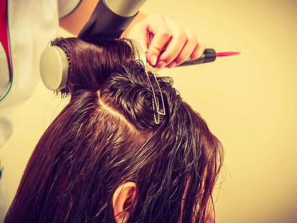 Coiffeur séchage cheveux féminins foncés en utilisant un sèche-cheveux professionnel — Photo