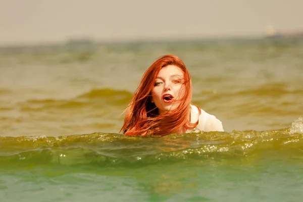 Roodharige vrouw spelen in water gedurende de zomermaanden — Stockfoto