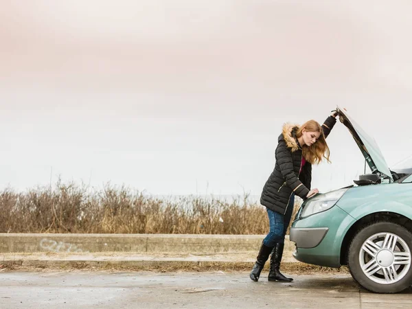 金发碧眼的女人和路上辆抛锚的汽车 — 图库照片