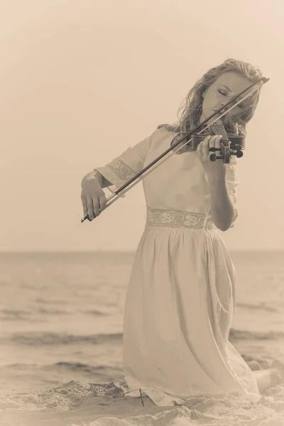 Frau spielt Geige auf Geige in Strandnähe — Stockfoto