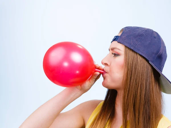 Adolescente chica soplando rojo globo . — Foto de Stock