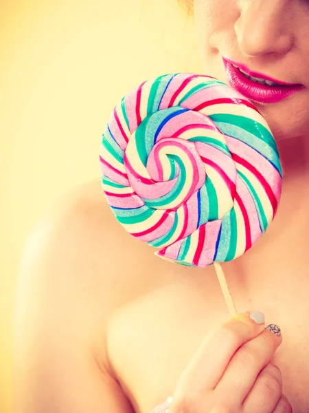 Woman holds colorful lollipop candy in hand — Stock Photo, Image