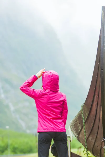 Tourist steht in der Nähe eines alten hölzernen Wikingerschiffs in norwegischer Natur — Stockfoto