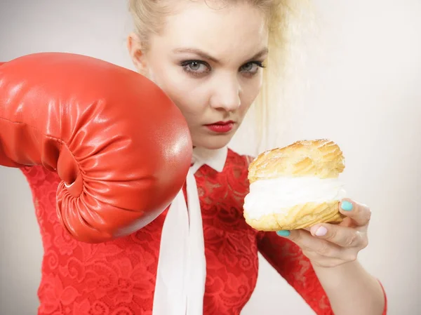 Mujer luchando contra la mala comida, pastel de crema de boxeo — Foto de Stock
