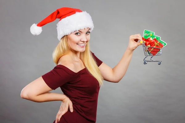 Santa woman holding shopping cart with christmas gifts — Stock Photo, Image