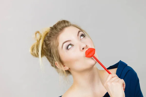 Funny woman holding big red lips on stick — Stock Photo, Image