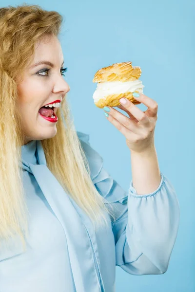 Mujer divertida sostiene pastel de crema de hojaldre — Foto de Stock