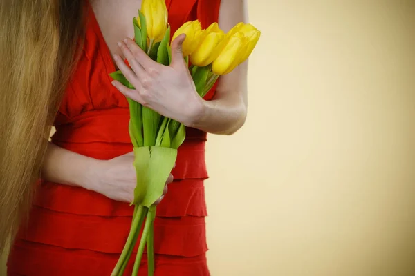 Frauenhand mit gelbem Tulpenstrauß — Stockfoto