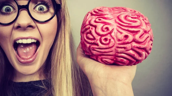 Mujer extraña sosteniendo el cerebro teniendo idea — Foto de Stock