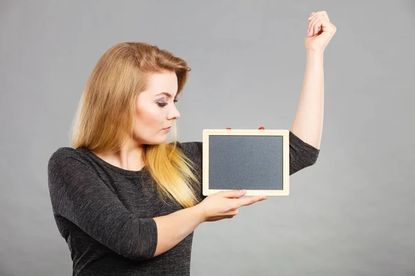 Vrouw met lege zwarte bord onder de oksel — Stockfoto