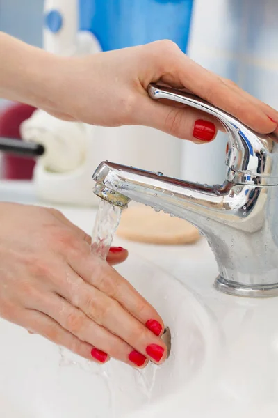 Woman washing hands under flowing tap water in the bathroom — Stock Photo, Image