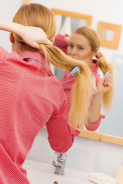 Hosszú haja fürdőszobában fésülködő nő — Stock Fotó