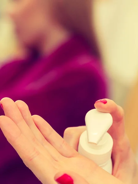 Donna che applica la crema per le mani sulle mani — Foto Stock
