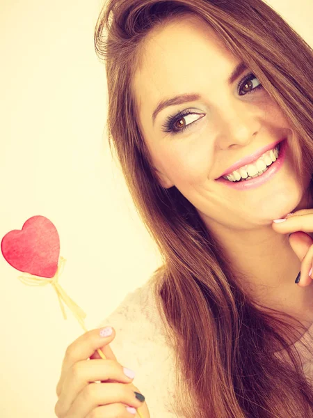 Mujer coqueta sosteniendo el corazón de madera roja en palo —  Fotos de Stock