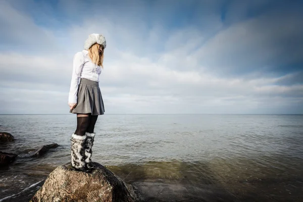 Mujer sobre piedras cerca del mar —  Fotos de Stock