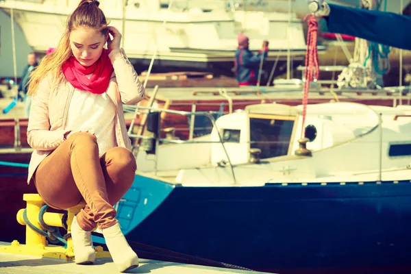 Женщина, сидящая на пристани для яхт — стоковое фото