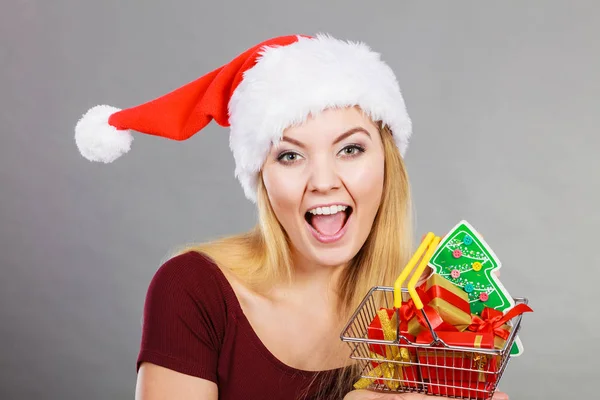 Santa mujer sosteniendo carrito de compras con regalos de Navidad — Foto de Stock