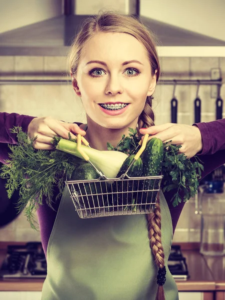 Mulher na cozinha com legumes segurando cesta de compras — Fotografia de Stock