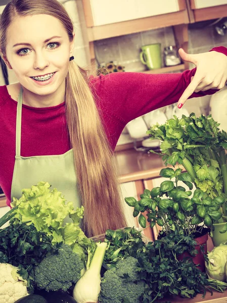 Kobieta w kuchni o wiele zielonych warzyw — Zdjęcie stockowe