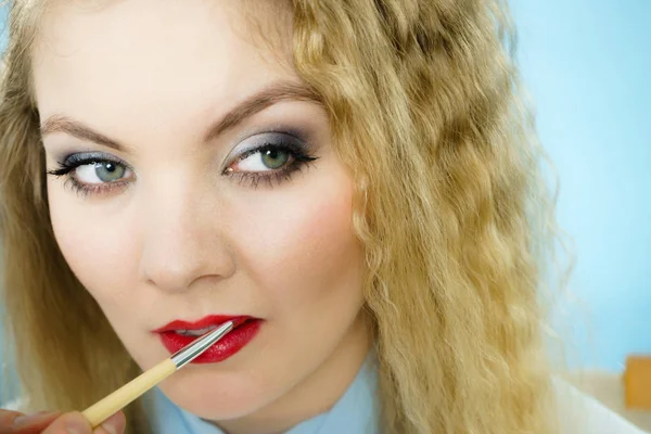 Het aanbrengen van lippenstift op modellippen — Stockfoto