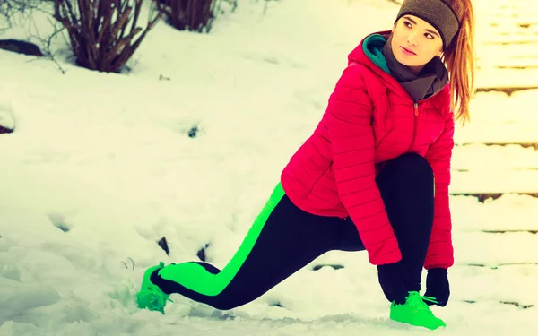 Vrouw het dragen van sportkleding uitoefenen buiten tijdens de winter — Stockfoto