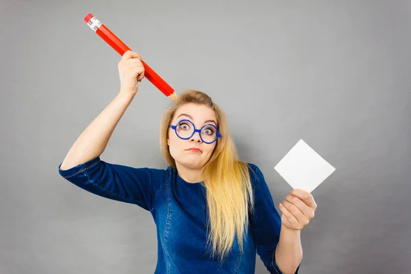 La donna confusa tiene in mano la grande carta da lettera a matita — Foto Stock