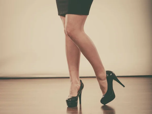 Vrouw zwarte hoge hakken en donkere rok dragen — Stockfoto