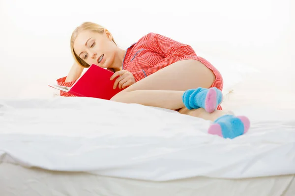 Vrouw in bed lezen boek ontspannen — Stockfoto