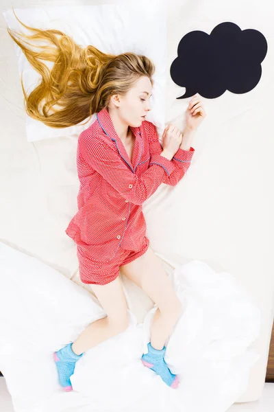 Junge Frau liegt im Schlafanzug auf dem Bett — Stockfoto