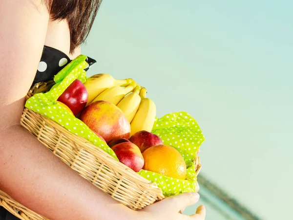 Vrouw met picknickmand met vruchten — Stockfoto