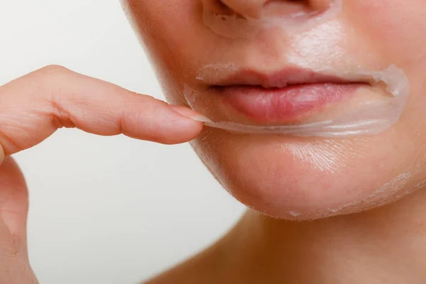 Woman removing facial peel off mask closeup — Stock Photo, Image