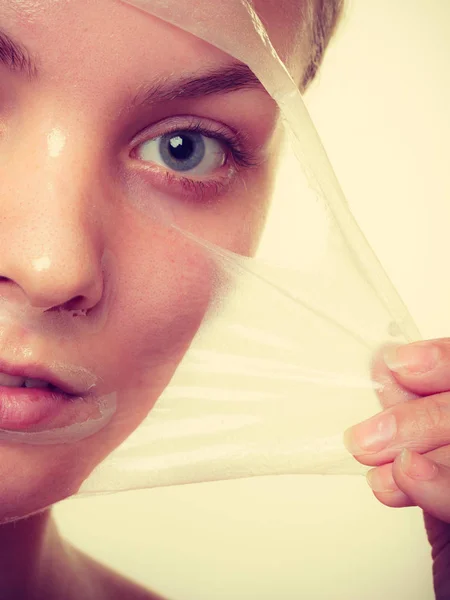 Frau entfernt Gesichtspeeling von Maske Nahaufnahme — Stockfoto