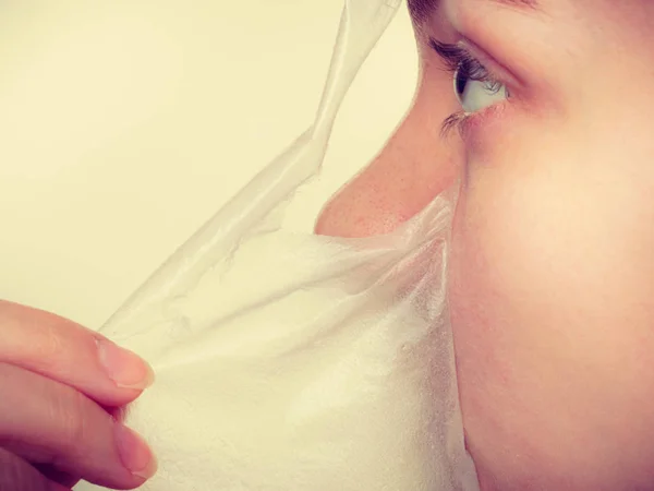 Frau entfernt Gesichtspeeling von Maske. — Stockfoto