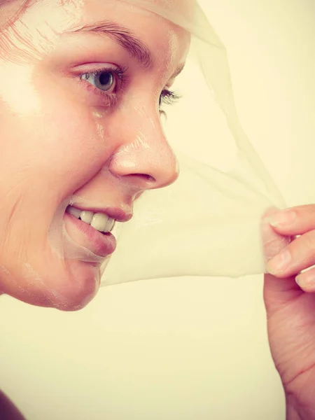 Mujer quitando la máscara de la piel facial . —  Fotos de Stock