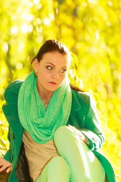 Грустная женщина, сидящая в зеленом парке — стоковое фото