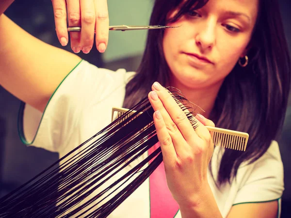 Hairdresser cutting woman dark long hair — Stock Photo, Image
