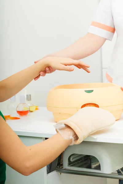 Frau bekommt Paraffin-Handbehandlung bei Kosmetikerin — Stockfoto