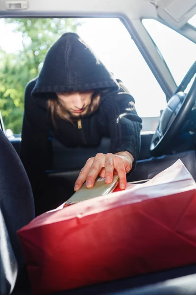 Einbrecher stehlen Smartphone und Tasche aus Auto — Stockfoto