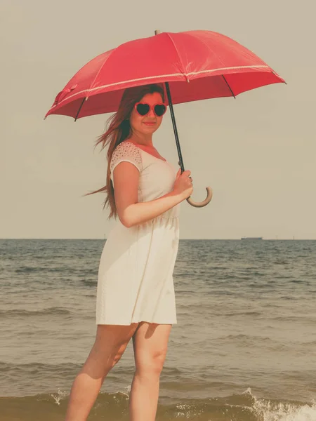 Zrzka žena na pláži drží deštník — Stock fotografie