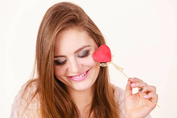 Flerte mulher segurando vermelho coração de madeira no pau — Fotografia de Stock