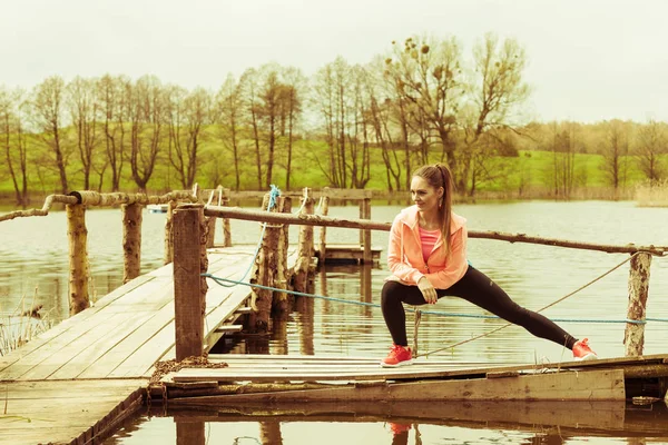 Girl training in sporty clothes on lake shore — Stock Photo, Image