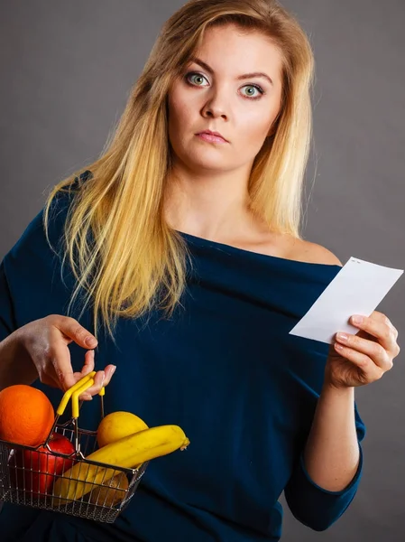 Orolig kvinna som håller varukorg med frukter — Stockfoto