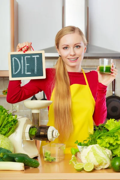 Woman in kitchen holding vegetable smoothie juice — Stock Photo, Image