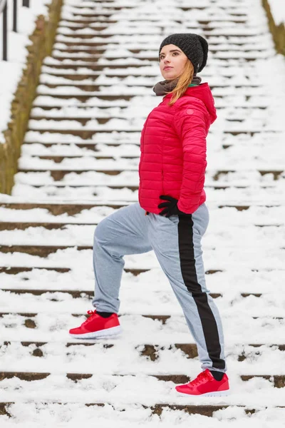 Mulher vestindo sportswear exercitando fora durante o inverno — Fotografia de Stock