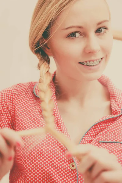 Kvinnan gör flätan på blonda hår — Stockfoto