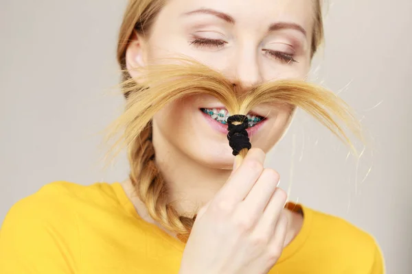 Frau macht Schnurrbart aus blonden Haaren — Stockfoto