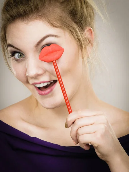 Mujer feliz sosteniendo los labios en palo — Foto de Stock