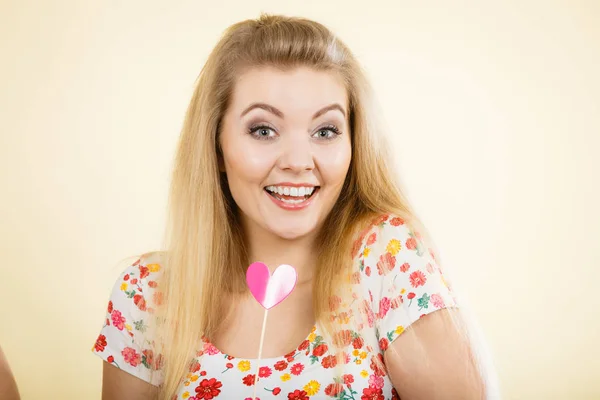 Mujer feliz sosteniendo el corazón en palo — Foto de Stock