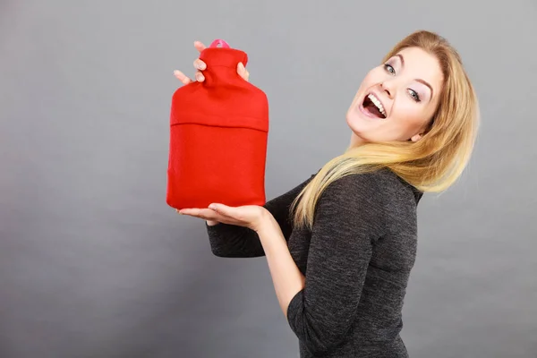 Happy woman holds hot water bottle — Stock Photo, Image